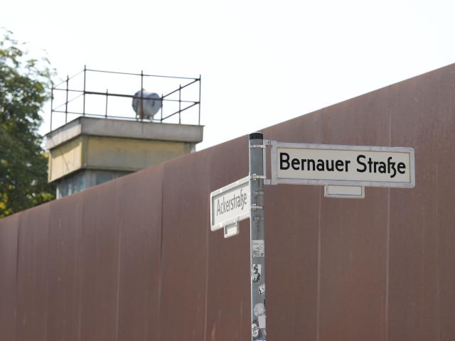 13 August 2026, Berlin: The watchtower, reminiscent of the inner-German border, stands behind the rust-colored steel wall of the Bernauer Strasse Memorial as the commemoration of the 65th anniversary of the construction of the Berlin Wall is about to begin. The wall artistically marks the course of the former death strip and the hinterland wall. Several events in Berlin are being held to commemorate the anniversary of the construction of the Berlin Wall. Photo: Sören Stache/dpa