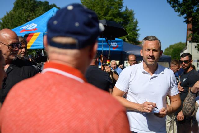 13 August 2026, Saxony-Anhalt, Loburg: Ulrich Siegmund, the AfD's lead candidate for the state election in Saxony-Anhalt, signs an autograph for a visitor at the AfD's information booth in Loburg. The state election in Saxony-Anhalt will take place on September 6, 2026. Photo: Klaus-Dietmar Gabbert/dpa