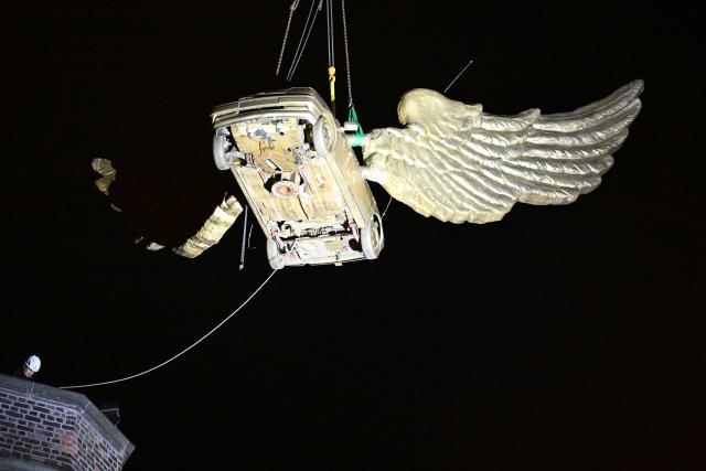 13 August 2026, North Rhine-Westphalia, Cologne: The golden winged car by Cologne artist HA Schult is being lifted by a crane from the tower of the historic armory because the building is dilapidated. Photo: Federico Gambarini/dpa - ACHTUNG: Nur zur redaktionellen Verwendung im Zusammenhang mit dem genannten Text und nur bei vollständiger Nennung des vorstehenden Credits