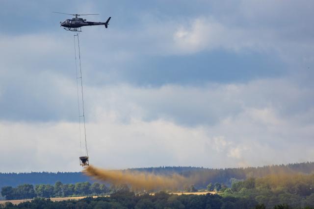 FILED - 28 July 2026, Sachsen, Glashuette: File Photo - A helicopter is spreading magnesium lime over a forested area near Glashuette as part of this year's soil protection liming program. Photo: Jürgen Lösel/dpa