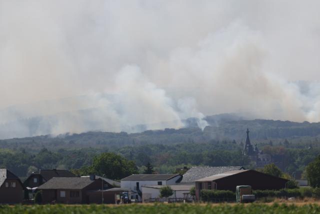 14 August 2026, North Rhine-Westphalia, Hürtgenwald: Smoke rises from a forest fire in the Hürtgenwald. Several hundred hectares of forest are ablaze. Photo: Rolf Vennenbernd/dpa