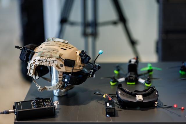 14 August 2026, Bavaria, Nuremberg: A helmet equipped with VR goggles and an accompanying police drone for kinetic drone defense are on display at a press conference at Nuremberg Airport focused on drone detection and defense. To best prepare the Bavarian police for current and future developments in this area and to further expand existing capabilities, the Drone Competence and Defense Center (DKAZ) began operations in Erding on April 1, 2026. Photo: Daniel Karmann/dpa