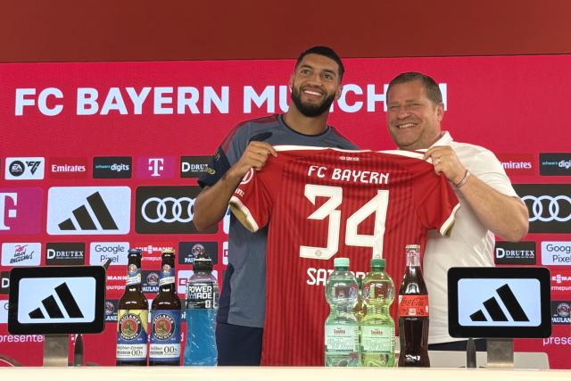 14 August 2026, Bavaria, Munich: FC Bayern Munich sporting director Max Eberl (R) and new signing Ismael Saibari hold up the No 34 jersey during his introduction press conference. Photo: Manuel Schwarz/dpa