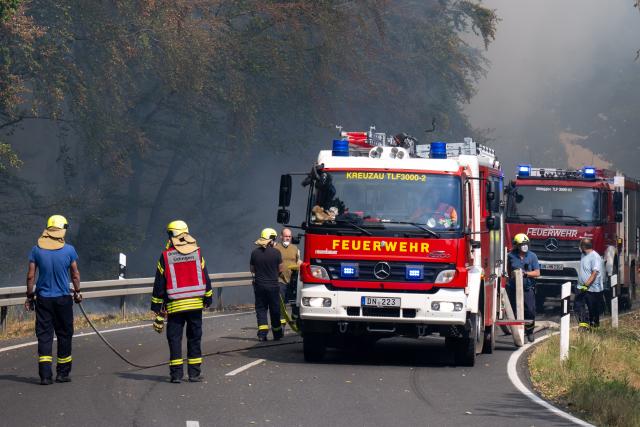 14 August 2026, North Rhine-Westphalia, Huertgenwald-Grosshau: Emergency responders battle the wildfire in the Huertgenwald along the B399. Photo: Harald Tittel/dpa