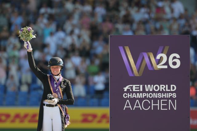 14 August 2026, North Rhine-Westphalia, Aachen: German rider Katharina Hemmer celebrates winning the bronze medal in the individual Grand Prix Special final at the World Championships. Photo: Rolf Vennenbernd/dpa