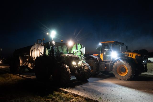 14 August 2026, North Rhine-Westphalia, Huertgenwald: Tractor drivers in Huertgenwald-Kleinhau wait for their water tanks to be filled so they can assist firefighters in battling the forest fire in the Huertgenwald. Photo: Harald Tittel/dpa