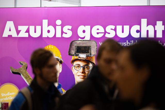 FILED - 19 January 2024, Saxony, Dresden: FILE PHOTO - Visitors stand in front of the sign reading "Apprentices Wanted" at the "KarriereStart" job fair. Photo: Sebastian Kahnert/dpa