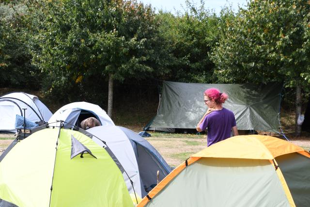 16 August 2026, Schleswig-Holstein, Sylt: A participant stands among the tents at the festival grounds as the punk protest camp on Sylt comes to an end on Sunday. Photo: Lea Albert/dpa
