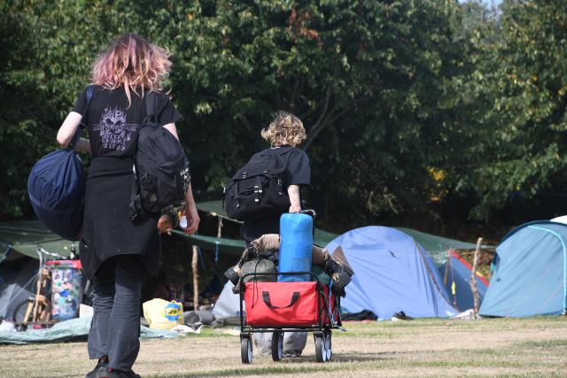 16 August 2026, Schleswig-Holstein, Sylt: Participants walk with their luggae across the festival grounds as the punk protest camp on Sylt comes to an end on Sunday. Photo: Lea Albert/dpa