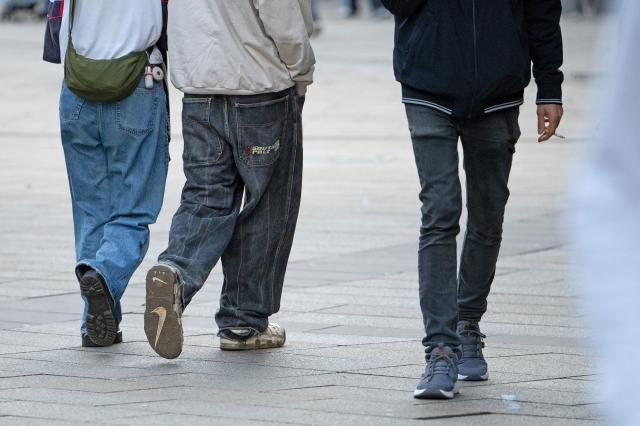 FILED - 16 January 2025, Baden-Württemberg, Stuttgart: FILE PHOTO - Three teenagers in jeans are seen walking. Photo: Helena Dolderer/dpa