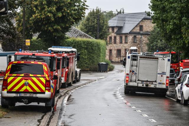 18 August 2026, North Rhine-Westphalia, Monschau: Fire department emergency vehicles are parked along the roadside in the Surbrot district. In the Hohes Venn nature reserve in Belgium, the battle against the wildfires continues. German emergency responders, operating out of the Eifel town of Monschau, are also involved. Photo: Oliver Berg/dpa