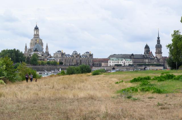 18 August 2026, Saxony, Dresden: A view across the Elbe River toward the historic Old Town skyline, featuring the Frauenkirche (L-R), the dome of the Academy of Fine Arts with the angel "Fama," the Staendehaus, the Hausmann Tower, and the Hofkirche. Photo: Robert Michael/dpa