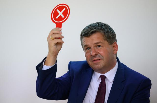 18 August 2026, Saxony-Anhalt, Halle/Saale: Minister President of Saxony-Anhalt Sven Schulze holds up a voting card during the election forum hosted by the Halle-Dessau Chamber of Commerce and Industry in Halle/Saale. Photo: Hendrik Schmidt/dpa