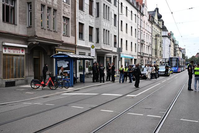 18 August 2026, Bavaria, Munich: Police officers stand at the scene, as emergency blankets lie on the sidewalk next to the police barrier tape. An incident involving the use of a firearm by police occurred in the Schwabing district of Munich. Photo: Felix Hörhager/dpa