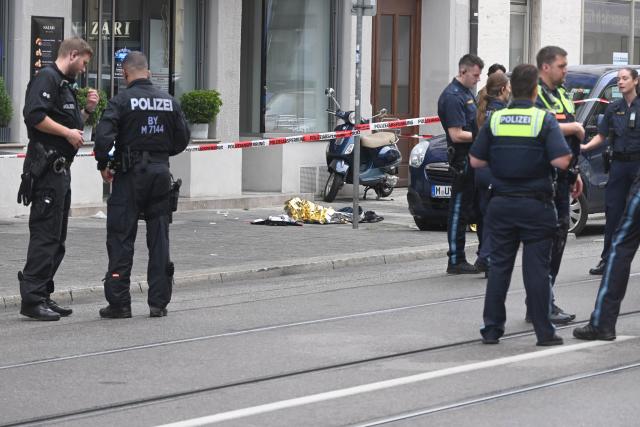 18 August 2026, Bavaria, Munich: Police officers stand at the scene, as emergency blankets lie on the sidewalk next to the police barrier tape. An incident involving the use of a firearm by police occurred in the Schwabing district of Munich. Photo: Felix Hörhager/dpa