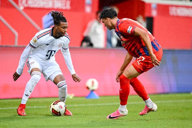 18 August 2026, Baden-Wuerttemberg, Heidenheim: Bayern Munich's Michael Olise (L) and Heidenheim's Mathias Honsak battle for the ball during the pre session friendly soccer match between 1. FC Heidenheim and FC Bayern Munich. Photo: Harry Langer/DeFodi/dpa/dpa - WICHTIGER HINWEIS: Gemäß den Vorgaben der Bundesliga bzw. des DFB Deutscher Fußball-Bund ist es untersagt, in dem Stadion und/oder vom Spiel angefertigte Fotoaufnahmen in Form von Sequenzbildern und/oder videoähnlichen Fotostrecken zu verwerten bzw. verwerten zu lassen.