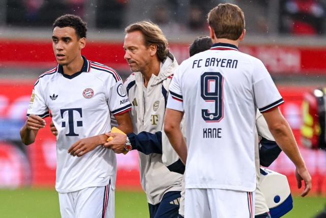 18 August 2026, Baden-Wuerttemberg, Heidenheim: Bayern Munich's Jamal Musiala (L) leaves the field with assistance during the pre session friendly soccer match between 1. FC Heidenheim and FC Bayern Munich. Photo: Harry Langer/dpa - WICHTIGER HINWEIS: Gemäß den Vorgaben der Bundesliga bzw. des DFB Deutscher Fußball-Bund ist es untersagt, in dem Stadion und/oder vom Spiel angefertigte Fotoaufnahmen in Form von Sequenzbildern und/oder videoähnlichen Fotostrecken zu verwerten bzw. verwerten zu lassen.