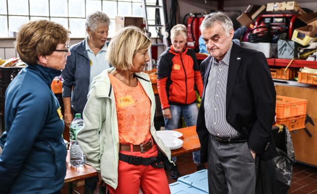 19 August 2026, North Rhine-Westphalia, Monschau: Herbert Reul, Minister of the Interior (R), speaks with volunteers in Kalterherberg. Fire departments continue to battle the blaze in the Hohen Venn. Photo: Oliver Berg/dpa