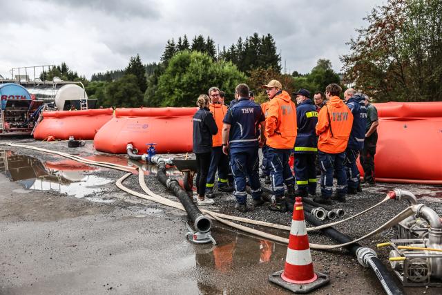 19 August 2026, North Rhine-Westphalia, Monschau: THW volunteers are stationed at a water refueling station on the German-Belgian border. Fire departments continue to battle the fire in the High Fens. Photo: Oliver Berg/dpa