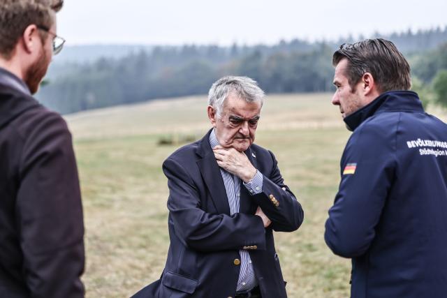 19 August 2026, North Rhine-Westphalia, Monschau: Herbert Reul, State Minister for Internal Affairs (C), speaks with representatives of the Aachen Urban Region at the German-Belgian border. Fire departments continue to battle the fire in the High Fens. Photo: Oliver Berg/dpa