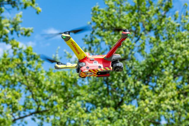 19 August 2026, Bavaria, Roding: A drone flies over a forested area. The system is being showcased as part of a project for early forest fire detection using AI-powered sensors. It is a cross-border EU project with partners from Germany and the Czech Republic. Photo: Armin Weigel/dpa