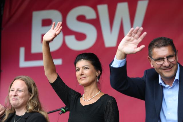 19 August 2026, Saxony-Anhalt, Dessau-Roßlau: Sahra Wagenknecht (C) founder of the Sahra Wagenknecht Alliance (BSW) and lead candidate Thomas Schulze (R) wave to the crowd in the town square as part of the BSW's campaign tour. Photo: Jan Woitas/dpa