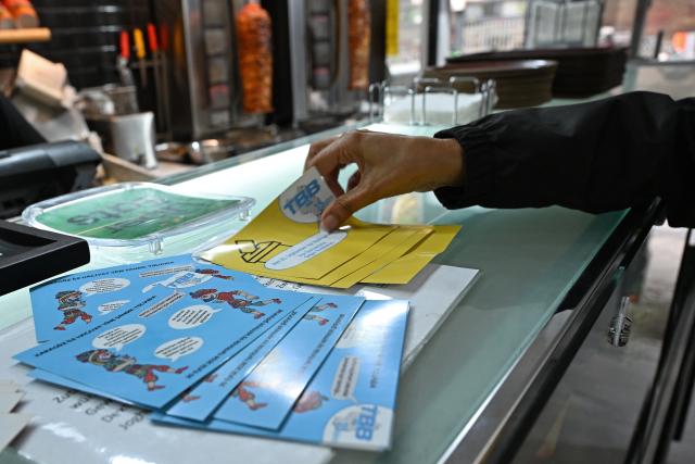19 August 2026, Berlin: Flyers from the Turkish Federation in Berlin-Brandenburg (TBB) are displayed at a doner stand, ahead of the Berlin House of Representatives election. The TBB is launching a campaign to increase voter turnout among citizens of Turkish descent. Photo: Michael Brandt/dpa