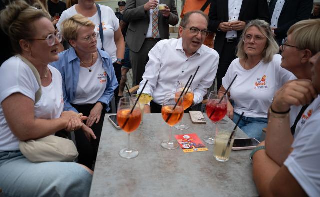 19 August 2026, Thuringia, Eisenach: German Interior Minister Alexander Dobrindt (C) talks with a group of locals at the market square in Eisenach. During his summer tour, Dobrindt is visiting various emergency response teams in Thuringia and Hesse. Photo: Katharina Kausche/dpa pool/dpa