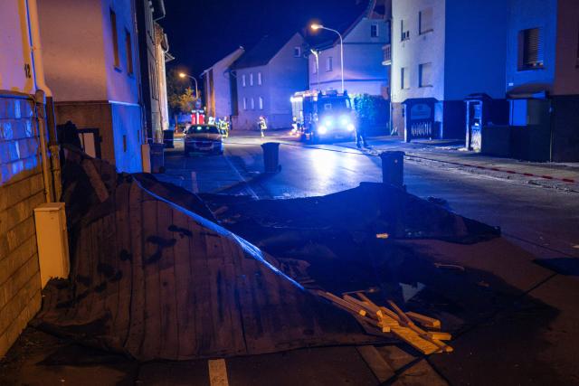 20 August 2026, Hesse, Wetzlar: Firefighters stand in front of damaged houses. Several houses in Wetzlar were damaged following a storm. Photo: Florian Wiegand/dpa
