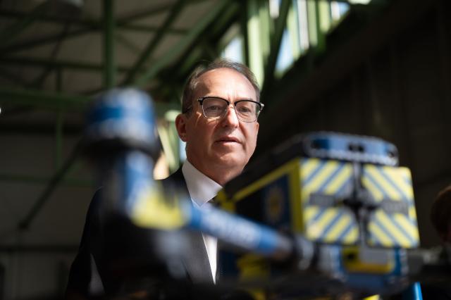 20 August 2026, Hesse, Fuldatal: Alexander Dobrindt, German Minister of the Interior, inspects a helicopter belonging to the Federal Police Air Squadron in Fuldatal inside a maintenance hangar. During his summer tour, Dobrindt is visiting various law enforcement agencies in Thuringia and Hesse. Photo: Katharina Kausche/dpa-Pool/dpa