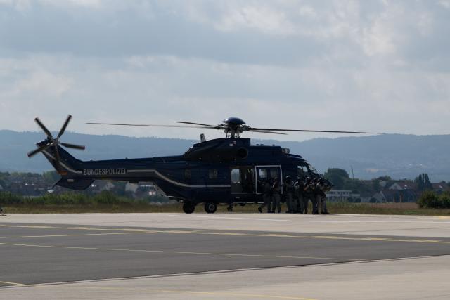 20 August 2026, Hesse, Fuldatal: Emergency responders are exiting a helicopter from the Federal Police Aviation Squadron in Fuldatal for an operational demonstration. German Interior Minister Alexander Dobrindt is visiting various emergency response teams in Thuringia and Hesse during his summer tour. Photo: Katharina Kausche/dpa pool/dpa