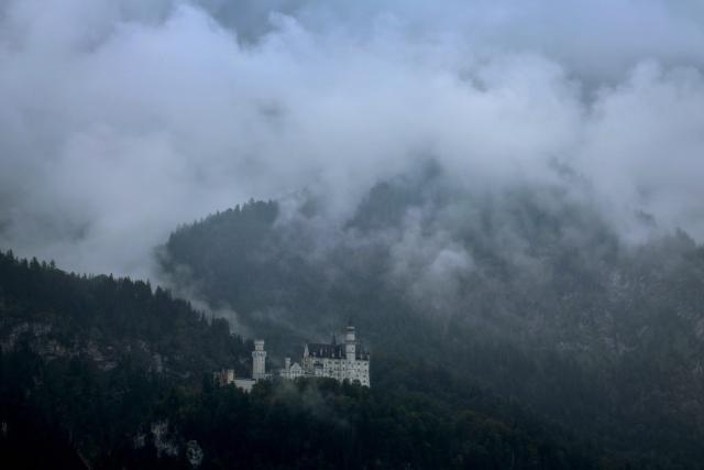 21 August 2026, Bavaria, Schwangau: Neuschwanstein Castle is shrouded in thick rain clouds. Photo: Karl-Josef Hildenbrand/dpa