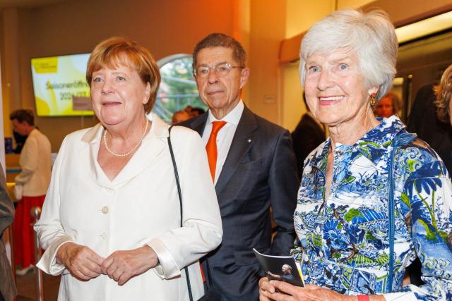 21 August 2026, Berlin: Angela Merkel (L) arrives at the Philharmonie with her husband, Joachim Sauer (C), and publisher Friede Springer (R), for the Philharmonic's season opening. Photo: Carsten Koall/dpa