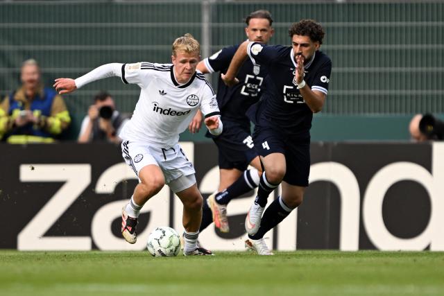 21 August 2026, North Rhine-Westphalia, Krefeld: Toenis' Memlan Darwish and Eintracht Frankfurt's Jonathan Burkardt battle for the ball during the German DFB Cup first Round soccer match between SC St. Toenis 11/20 and Eintracht Frankfurt at the Grotenburg Stadium. Photo: Federico Gambarini/dpa - IMPORTANT NOTICE: Bundesliga and DFB regulations prohibit any use of photographs as image sequences and/or quasi-video.