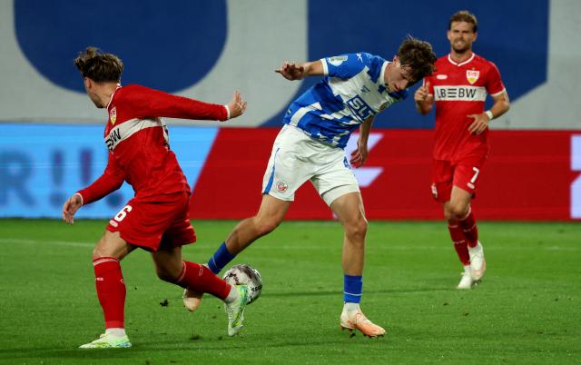 21 August 2026, Mecklenburg-Western Pomerania, Rostock: Stuttgart's Angelo Stiller and Hansa's Yannik Michaelis battle for the ball during the German DFB Cup first round soccer match between Hansa Rostock and VfB Stuttgart at the Ostseestadion. Photo: Bernd Wüstneck/dpa - IMPORTANT NOTICE: Bundesliga and DFB regulations prohibit any use of photographs as image sequences and/or quasi-video.