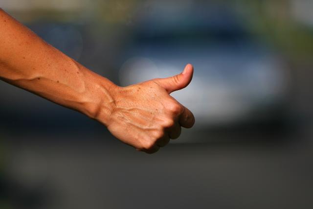 FILED - 14 August 2007, Berlin: FILE PHOTO - A woman holds up her thumb in an attempt to hitch a ride. Photo: Arno Burgi/dpa-Zentralbild/dpa