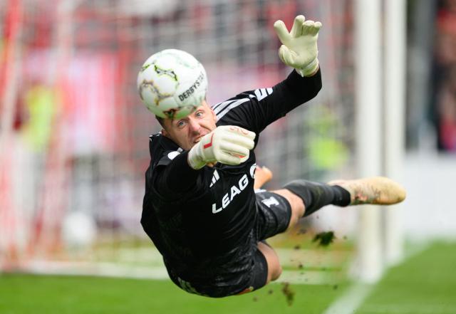 22 August 2026, Brandenburg, Cottbus: Energie Cottbus goalkeeper Marcel Lotka saves the ball during the German DFB Cup first round soccer match between FC Energie Cottbus and FC Augsburg at LEAG Energie Stadium. Photo: Robert Michael/dpa - IMPORTANT NOTICE: In accordance with the regulations of the Bundesliga and the German Football Association (DFB), it is prohibited to use or allow the use of photographs taken in the stadium and/or during the game in the form of sequential images and/or video-like photo sequences.