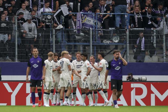 22 August 2026, Saxony, Aue: Hoffenheim's Patrick Wimmer (C) celebrates scoring his side's first goal with teammates during the German Cup (DFB Pokal) first round soccer match between Erzgebirge Aue vs TSG 1899 Hoffenheim at Erzgebirgsstadion. Photo: Jan Woitas/dpa - IMPORTANT NOTICE: Bundesliga and DFB regulations prohibit any use of photographs as image sequences and/or quasi-video.