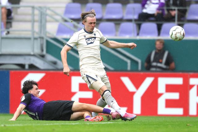 22 August 2026, Saxony, Aue: Hoffenheim's Patrick Wimmer and Erzgebirge Aue's Maxim Burghardt battle for the ball during the German Cup (DFB Pokal) first round soccer match between Erzgebirge Aue vs TSG 1899 Hoffenheim at Erzgebirgsstadion. Photo: Jan Woitas/dpa - IMPORTANT NOTICE: Bundesliga and DFB regulations prohibit any use of photographs as image sequences and/or quasi-video.