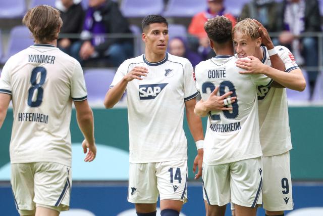 22 August 2026, Saxony, Aue: (L-R) Hoffenheim's Max Moerstedt celebrates scoring his side's third goal with teammates Bambase Conte, Adam Daghim, and Patrick Wimmer during the German Cup (DFB Pokal) first round soccer match between Erzgebirge Aue vs TSG 1899 Hoffenheim at Erzgebirgsstadion. Photo: Jan Woitas/dpa - IMPORTANT NOTICE: Bundesliga and DFB regulations prohibit any use of photographs as image sequences and/or quasi-video.
