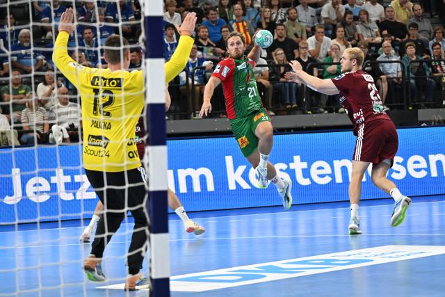 22 August 2026, Bavaria, Munich: Matthes Langhoff (R) and goalkeeper Andreas Palicka of Fuechse Berlin face off against Albin Lagergren (C) of SC Magdeburg, during the DHB Super Cup final handball match between SC Magdeburg and Fuechse Berlin, at the SAP Garden. Photo: Angelika Warmuth/dpa
