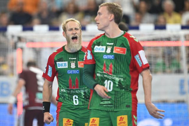 22 August 2026, Bavaria, Munich: Matthias Musche (L) and Gisli Thorgeir Kristjansson of SC Magdeburg celebrate during the DHB Super Cup final handball match between SC Magdeburg and Fuechse Berlin, at the SAP Garden. Photo: Angelika Warmuth/dpa