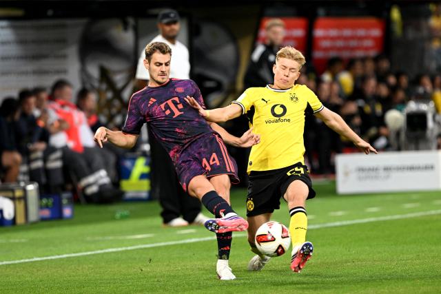 22 August 2026, Dortmund: Bayern Munich's Josip Stanisic and Borussia Dortmund's Daniel Svensson battle for the ball during the German Franz Beckenbauer Supercup soccer match between Borussia Dortmund and FC Bayern Munich at the Signal Iduna Park. Photo: Federico Gambarini/dpa - IMPORTANT NOTICE: Bundesliga and DFB regulations prohibit any use of photographs as image sequences and/or quasi-video.
