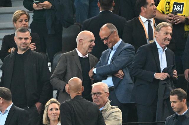 22 August 2026, Dortmund: Bernd Neudorf, President of the German Football Association (DFB) speaks with German Chancellor Friedrich Merz (C-R) alongside Joachim Watzke (R), first DFB vice president, and Mona Neubaur (top L), deputy minister-president of North Rhine-Westphalia during the German Franz Beckenbauer Supercup soccer match between Borussia Dortmund and FC Baye
rn Munich at the Signal Iduna Park. Photo: Federico Gambarini/dpa - IMPORTANT NOTICE: Bundesliga and DFB regulations prohibit any use of photographs as image sequences and/or quasi-video.