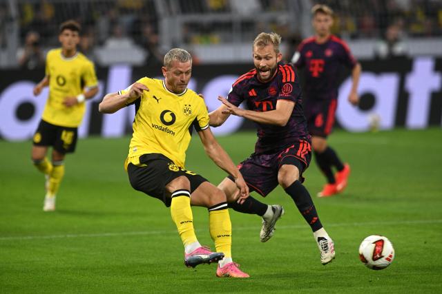 22 August 2026, Dortmund: Borussia Dortmund's Julian Ryerson (L) and Bayern Munich's Konrad Laimer battle for the ball during the German Franz Beckenbauer Supercup soccer match between Borussia Dortmund and FC Bayern Munich at the Signal Iduna Park. Photo: Bernd Thissen/dpa - IMPORTANT NOTICE: Bundesliga and DFB regulations prohibit any use of photographs as image sequences and/or quasi-video.