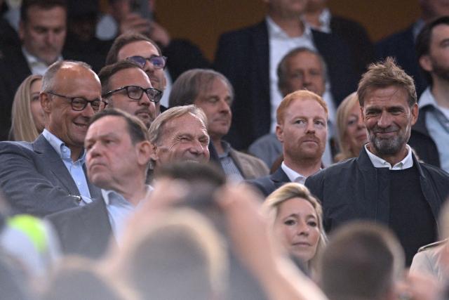 22 August 2026, Dortmund: German Chancellor Friedrich Merz, Dortmund president and DFB vice-president Hans-Joachim Watzke, and national team coach Jurgen Klopp attend the German Franz Beckenbauer Supercup soccer match between Borussia Dortmund and FC Bayern Munich at the Signal Iduna Park. Photo: Bernd Thissen/dpa - IMPORTANT NOTICE: Bundesliga and DFB regulations prohibit any use of photographs as image sequences and/or quasi-video.