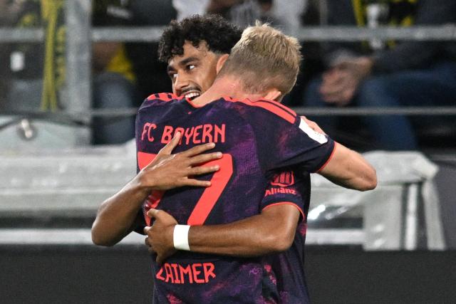 22 August 2026, Dortmund: Bayern Munich's Nathaniel Brown (L) celebrates scoring his side's first goal with teammate Konrad Laimer during the German Franz Beckenbauer Supercup soccer match between Borussia Dortmund and FC Bayern Munich at the Signal Iduna Park. Photo: Bernd Thissen/dpa - IMPORTANT NOTICE: Bundesliga and DFB regulations prohibit any use of photographs as image sequences and/or quasi-video.