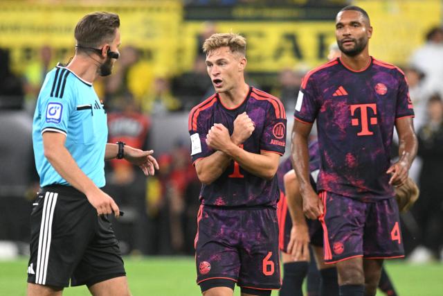 22 August 2026, Dortmund: Referee Daniel Schlager speaks with Bayern Munich's Joshua Kimmich and Bayern Munich's Jonathan Tah during the German Franz Beckenbauer Supercup soccer match between Borussia Dortmund and FC Bayern Munich at the Signal Iduna Park. Photo: Bernd Thissen/dpa - IMPORTANT NOTICE: Bundesliga and DFB regulations prohibit any use of photographs as image sequences and/or quasi-video.