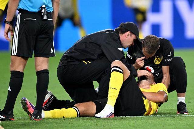 22 August 2026, Dortmund: Borussia Dortmund's Ramy Bensebaini receives medical attention during the German Franz Beckenbauer Supercup soccer match between Borussia Dortmund and FC Bayern Munich at the Signal Iduna Park. Photo: Federico Gambarini/dpa - IMPORTANT NOTICE: Bundesliga and DFB regulations prohibit any use of photographs as image sequences and/or quasi-video.