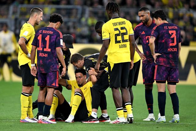 22 August 2026, Dortmund: Borussia Dortmund's Ramy Bensebaini receives medical attention during the German Franz Beckenbauer Supercup soccer match between Borussia Dortmund and FC Bayern Munich at the Signal Iduna Park. Photo: Federico Gambarini/dpa - IMPORTANT NOTICE: Bundesliga and DFB regulations prohibit any use of photographs as image sequences and/or quasi-video.